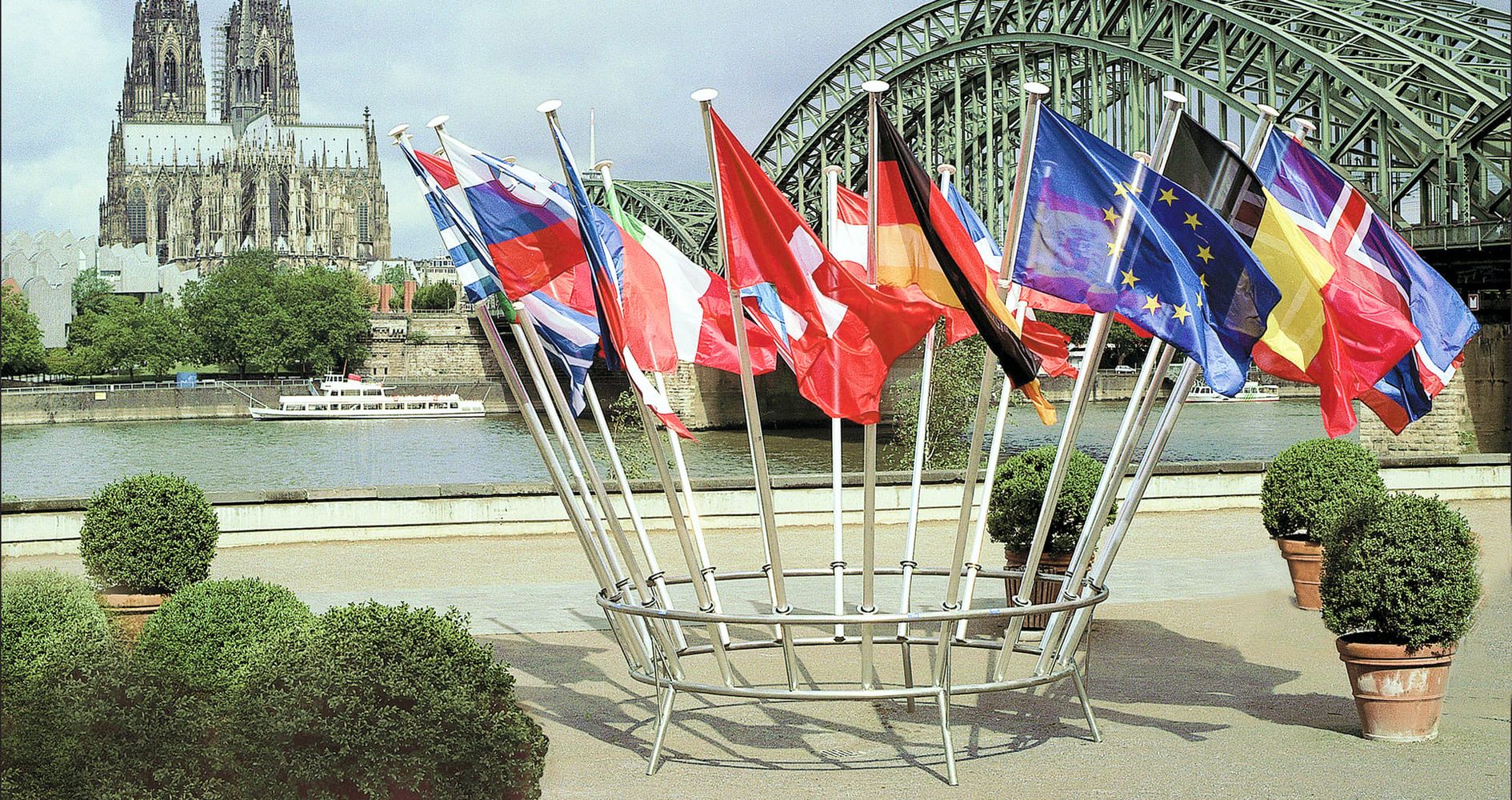 Mobile Fahnenmaste mit Flaggen von europäischen Ländern steht in Köln mit dem Dom im Hintergrund
