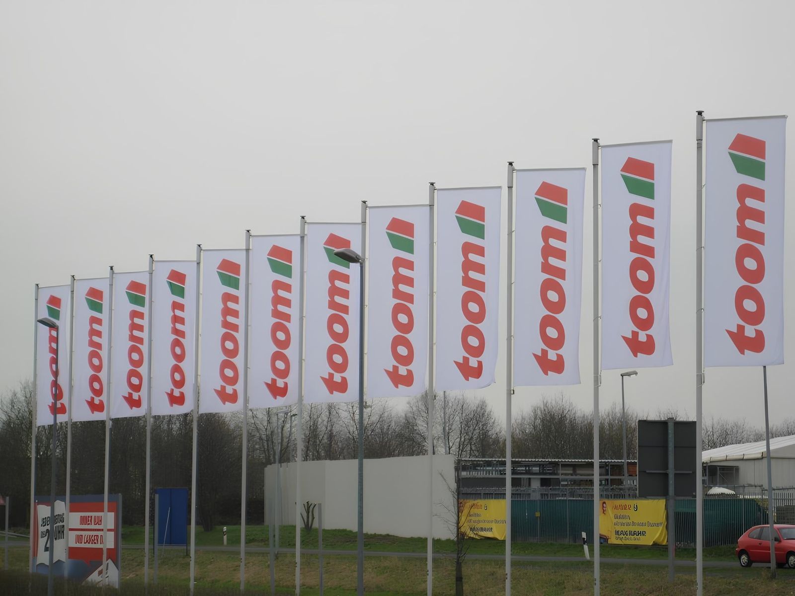 Fahnen an Fahnenmästen auf dem Parkplatz von Baumarkt Toom